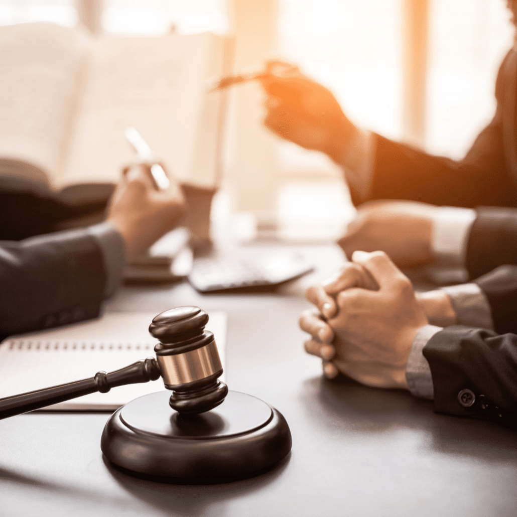 photo of a gavel with people's hands in the background